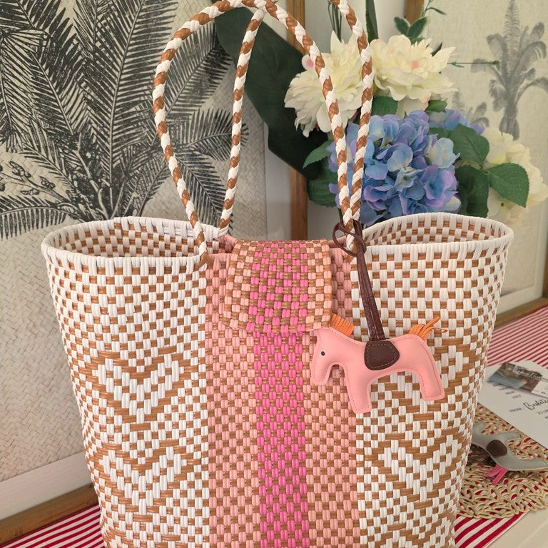 a woven pink bag with a love heart pattern