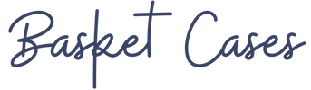 The text 'Basket Cases' written in a dark navy blue cursive script on a solid white background.